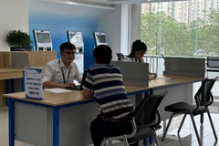 Người dân làm thủ tục hành chính tại Trung tâm phục vụ hành chính công thành phố Hà Nội, chi nhánh số 1. (Ảnh: DIỆU THƯƠNG)