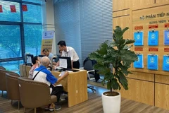 Người dân làm thủ tục hành chính trực tuyến tại Trung tâm phục vụ hành chính công thành phố Hà Nội, chi nhánh số 3. (Ảnh: DIỆU THƯƠNG)