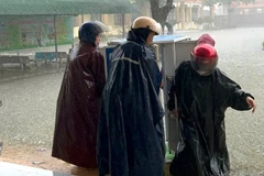 Giáo viên ở xã Quảng Trạch, Quảng Trị, di chuyển tài sản lên cao tránh hư hỏng khi nước lũ đã tràn vào sân trường hôm 31/10. (Ảnh: HƯƠNG GIANG)