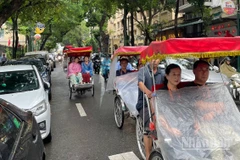 Du khách nước ngoài trên phố Tràng Thi (Hà Nội) ngày mưa. (Ảnh minh họa: Đ.T)