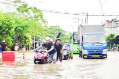 Triều cường gây ngập nặng tuyến đường Đào Sư Tích, xã Nhà Bè, làm đảo lộn cuộc sống của người dân. (Ảnh THẾ ANH)