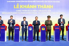 Các đại biểu thực hiện nghi lễ cắt băng khánh thành công trình đưa điện lưới quốc gia đến với bản Phảng Củ và bản Háng Chua, xã Sáng Nhè (Điện Biên).