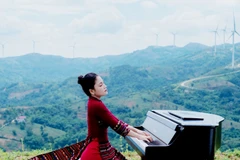Hoa Ngọc Hà trong một chương trình ghi hình mới đây với trang phục áo dài chất liệu thổ cẩm của đồng bào Bru-Vân Kiều cùng cây đàn piano, tại quê nhà Khe Sanh. (Ảnh TRẦN TIẾN ĐẠT)