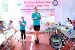 Phạm Thành Nam biểu diễn tiết mục "Tung hứng 6 quả bóng, vừa đứng thăng bằng trên quả bóng tròn, vừa đội chai trên đầu" 