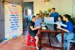 Đoàn viên, thanh niên tình nguyện hướng dẫn người dân nộp hồ sơ và trao giấy xác nhận mức độ khuyết tật tại nhà ở phường Cao Lãnh (tỉnh Đồng Tháp).