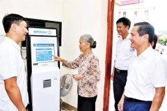 Cán bộ xã Đại Đồng hướng dẫn người dân làm thủ tục hành chính trên máy.