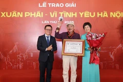 Đồng chí Lê Quốc Minh, Ủy viên Trung ương Đảng, Tổng Biên tập Báo Nhân Dân, Phó Trưởng ban Tuyên giáo và Dân vận Trung ương, Chủ tịch Hội Nhà báo Việt Nam cùng lãnh đạo Thông tấn xã Việt Nam trao Giải thưởng Lớn - Vì tình yêu Hà Nội được trao cho nhạc sĩ Trần Tiến.