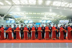 Phó Thủ tướng thường trực Nguyễn Hòa Bình và các đại biểu thực hiện nghi thức cắt băng khánh thành Dự án mở rộng Nhà ga hành khách T2 Cảng hàng không quốc tế Nội Bài. Ảnh: TTXVN