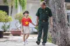 Thượng sĩ Nguyễn Chí Tường cùng con một nhân viên Vinamilk tại Trung tâm Điều dưỡng Thương binh và Người có công Long Đất. (Ảnh: THANH BÌNH)