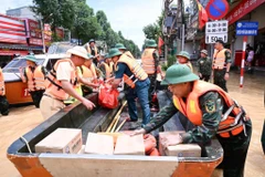 Các lực lượng Quân đội và Công an chở nhu yếu phẩm tiếp tế cho người dân vùng bị ngập lụt ở Thái Nguyên. (Ảnh: TRẦN HẢI)