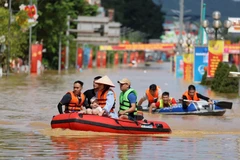 Nước ngập sâu, người dân phải dùng xuồng cao su để di chuyển trên tuyến đường Hoàng Văn Thụ, phường Phan Đình Phùng (Thái Nguyên). Ảnh: TTXVN