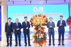 Thứ trưởng Y tế Trần Văn Thuấn tặng hoa chúc mừng Ban giám đốc Bệnh viện Đà Nẵng tổ chức thành công hội nghị. (Ảnh: ANH ĐÀO)