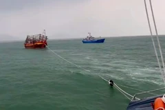 Tàu cứu nạn lai dắt tàu cá bị nạn vào bờ. (Ảnh: Bộ đội Biên phòng cung cấp)