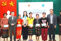 Các đại biểu trao trợ giúp tiền mặt cho hộ gia đình bị ảnh hưởng thiên tai ở xã Kim Ngân (Ảnh: NH)