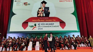 Tiến sĩ Ngô Minh Đức, Hiệu trưởng Trường Đại học Quốc tế Miền Đông (bên trái) trao Bằng tốt nghiệp đại học cho các tân cử nhân.