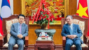 Phó Thủ tướng Chính phủ Lào Saleumxay Kommasith tới thăm và chúc mừng Đại sứ quán Việt Nam tại Lào. (Ảnh: Cộng tác viên)