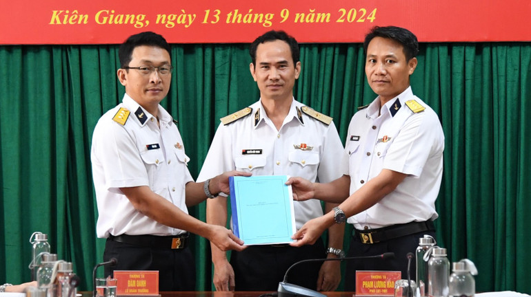 Thượng tá Đàm Oanh (trái trao biên bản bàn giao chức trách, nhiệm vụ Lữ đoàn trưởng Lữ đoàn 127 cho Thượng tá Phạm Lương Hào (phải).