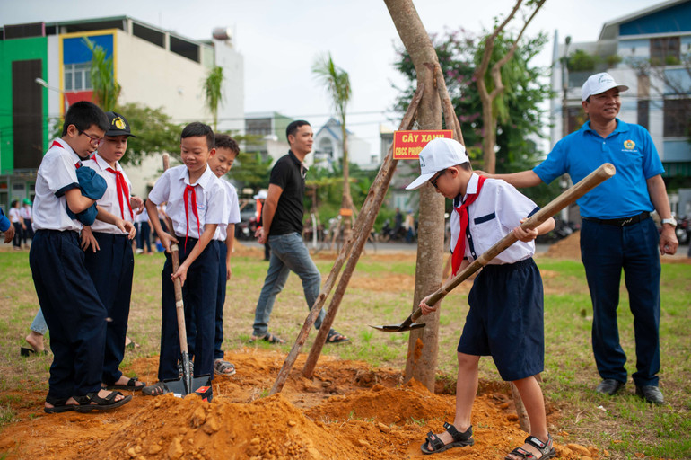 Các em học sinh hào hứng trồng các loại cây xanh tại Khu công viên vườn dạo khu số 1 - Trung tâm đô thị mới Tây Bắc.