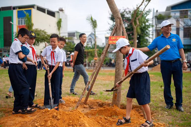 Các em học sinh hào hứng trồng các loại cây xanh tại Khu công viên vườn dạo khu số 1 - Trung tâm đô thị mới Tây Bắc.