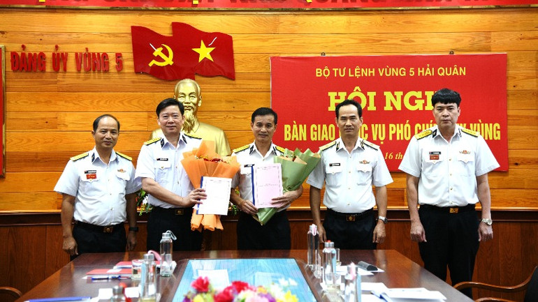 Chuẩn Đô đốc Nguyễn Hữu Thoan (thứ hai từ phải qua) tặng hoa chúc mừng Đại tá Lê Văn Hưởng và Đại tá Hoàng Quốc Hoàn.