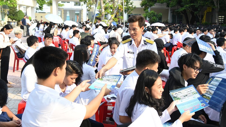 Báo cáo viên của Vùng 5 Hải quân phát tờ rơi tuyên truyền về Học viện Hải quân.