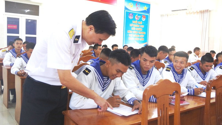 Chỉ huy Lữ đoàn hướng dẫn chiến sĩ trẻ làm bài kiểm tra nhận thức pháp luật.