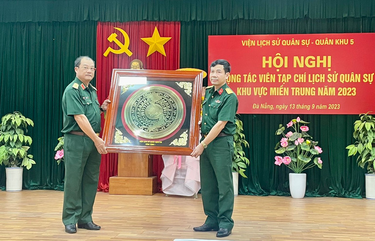 Đại tá, PGS, TS Dương Hồng Anh, Phó Viện trưởng Viện Lịch sử quân sự tặng bức tranh Trống đồng Đông Sơn cho đại diện Bộ Tư lệnh quân khu 5.