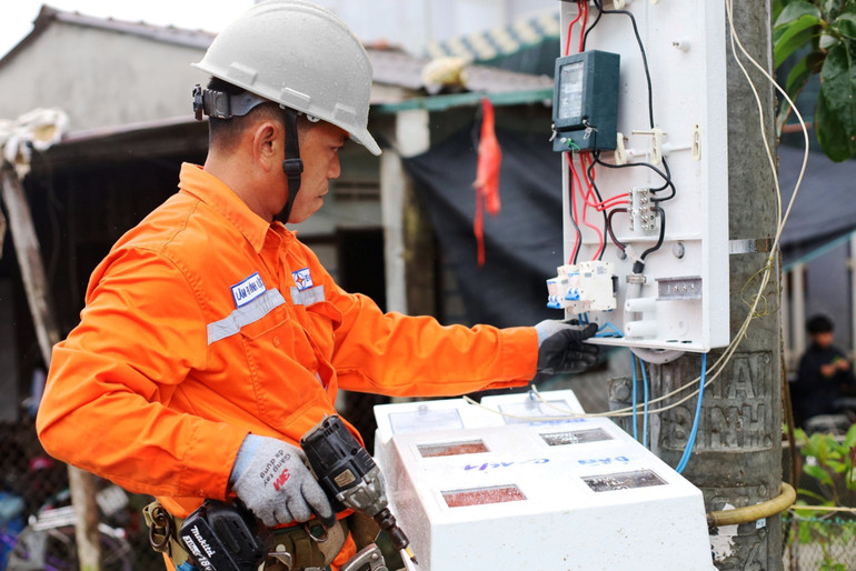 Công nhân Điện lực Đà Nẵng lắp đặt công-tơ đo đếm mới cho khách hàng.