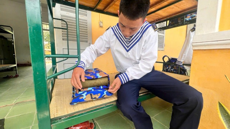 Chiến sĩ mới rèn động tác gấp chăn màn lần đầu tiên.