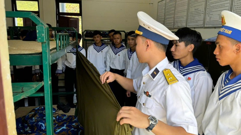 Hướng dẫn chiến sĩ mới gấp chăn màn.