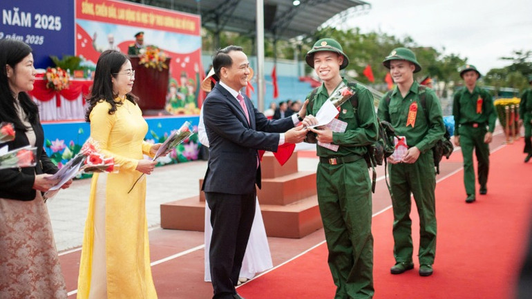 Đồng chí Nguyễn Đình Vĩnh, Phó Bí thư Thường trực Thành ủy Đà Nẵng, tặng hoa cho các thanh niên quận Ngũ Hành Sơn lên đường nhập ngũ.