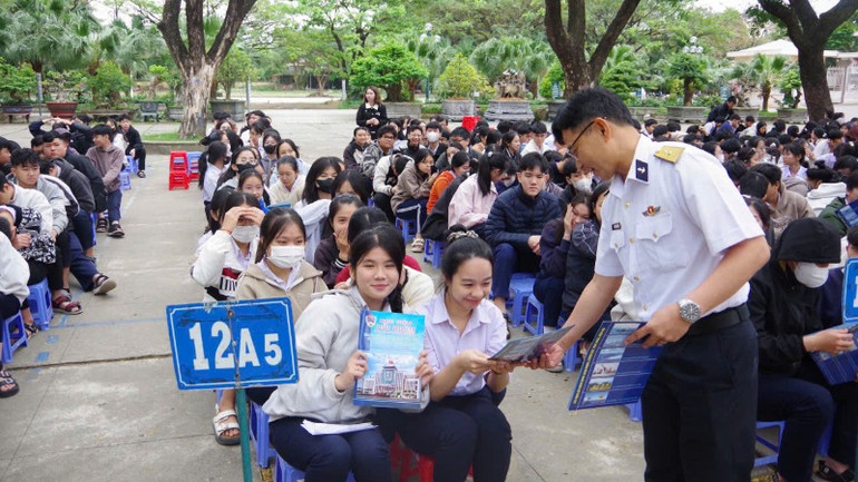 Báo cáo viên tuyên truyền, phát tờ rơi về thu hút nguồn lực tại Trường THPT Trần Cao Vân.