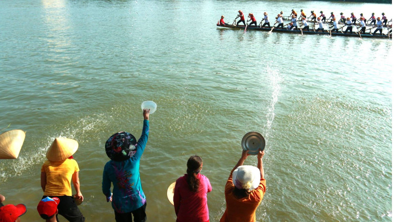 Bằng mọi dụng cụ có trong tay, người dân lao ra mép nước để cổ động cho các thuyền đua, bơi, nhờ thế vận động viên như được truyền thêm được sức mạnh để đưa thuyền vượt lên.
