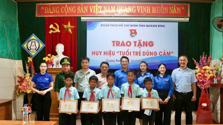 Các đại biểu chụp ảnh lưu niệm cùng với 5 bạn nhỏ mưu trí, dũng cảm.