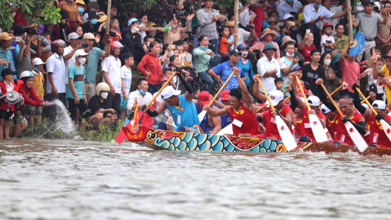 Người dân Lệ Thủy xuống tận mép nước để cổ vũ cho thuyền bơi làng mình.