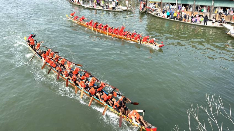 Các thuyền bơi nam tranh đua quyết liệt để vượt lên