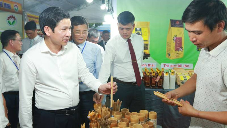 Đại biểu tham quan một gian hàng tiểu thủ công nghiệp tại hội chợ.