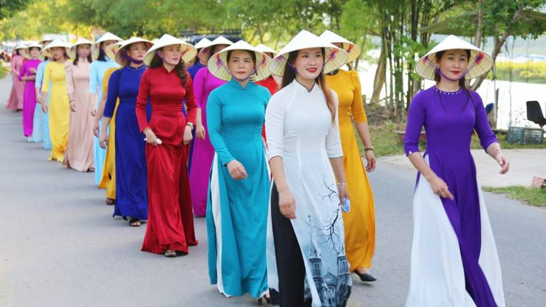 Phụ nữ mang áo dài diễu hành trên tuyến đường ven bờ sông Son.