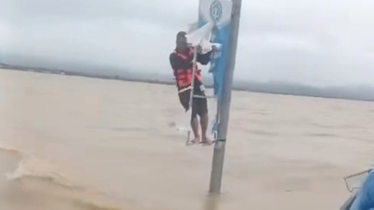 Ông Trương Văn Duy đu bám vào cột điện xuyên đêm giữa lũ đến sáng nay thì được cứu.