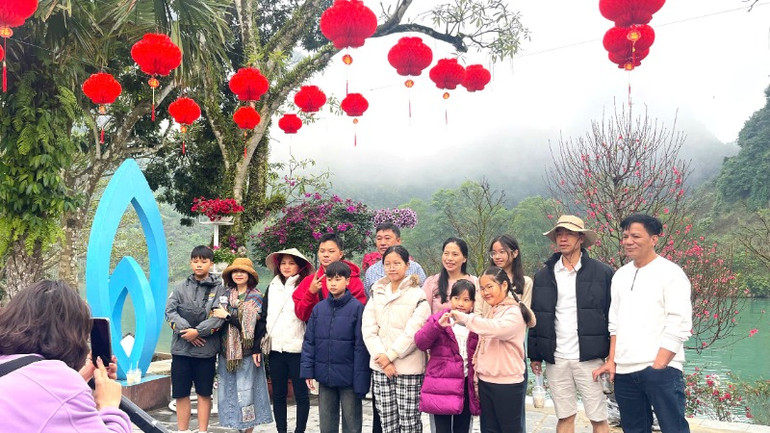 Du khách cùng nhau lưu lại bức ảnh đầu xuân bên dòng sông Son.