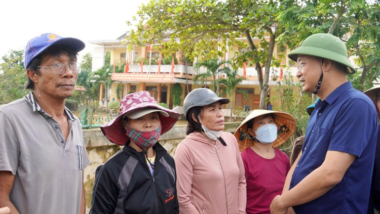 Đồng chí Lê Ngọc Quang trò chuyện với bà con vùng lũ Quảng Bình.