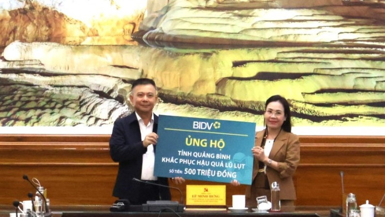 Đại diện Ngân hàng thương mại cổ phần Đầu tư và Phát triển Việt Nam trao 500 triệu đồng cho tỉnh Quảng Bình để hỗ trợ người dân vùng lũ.