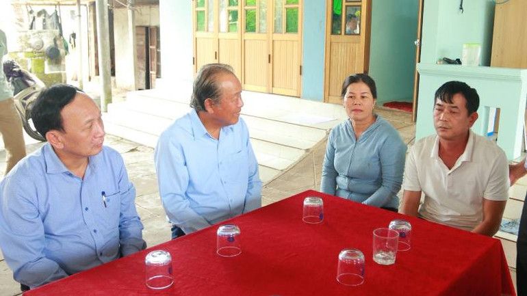 Nguyên Phó Thủ tướng Thường trực Chính phủ Trương Hòa Bình và đại diện lãnh đạo tỉnh Quảng Bình trò chuyện với gia đình ngư dân.