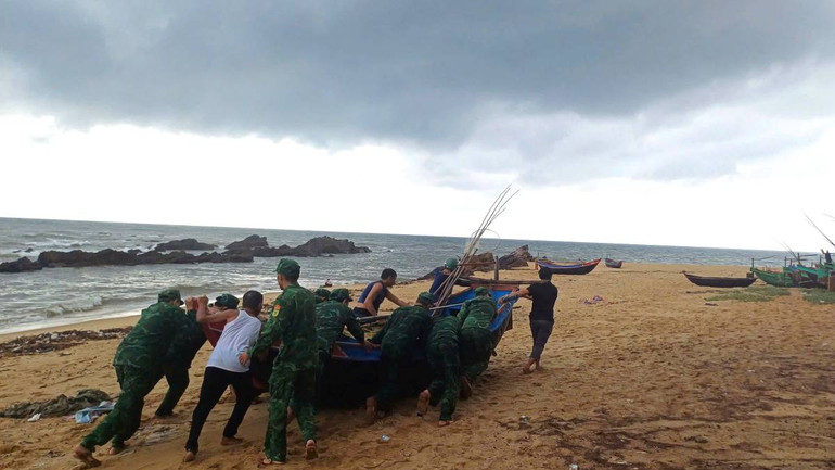 Bộ đội biên phòng hỗ trợ ngư dân xã hải Ninh, huyện Quảng Ninh đưa thuyền đánh cá lên bờ chạy bão.