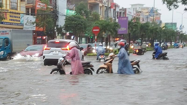 Xe chết máy, nhiều người phải dắt bộ lội qua đoạn đường phố ngập.