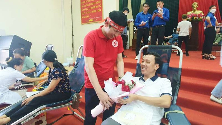 Phó Chủ tịch Ủy ban nhân dân tỉnh Quảng Bình Hồ An Phong tặng hoa, động viên cho tình nguyện viên hiến máu.