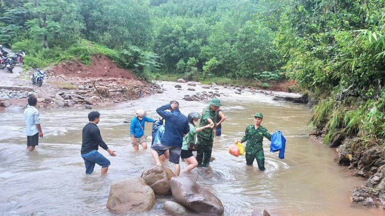 Các chiến sĩ biên phòng hỗ trợ nữ giáo viên cắm bản lội qua các ngầm tràn bị hư hỏng sau mưa lũ.
