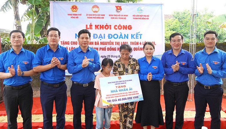 Các đại biểu trao biển tượng trưng hỗ trợ kinh phí xây nhà cho gia đình có hoàn cảnh khó khăn.
