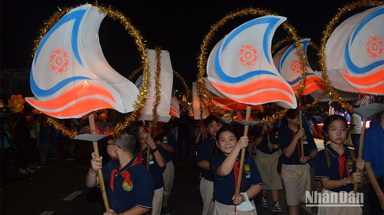 Học sinh trường tiểu học, THCS và THPT Lê Quý Đôn rước lồng đèn nhỏ với hình ảnh logo năm Du lịch quốc gia 2023 “ Bình Thuận - Hội tụ xanh”.