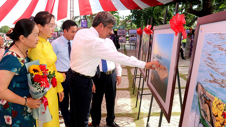Các đại biểu xem, thưởng thức các tác phẩm nhiếp ảnh được trưng bày tại Triển lãm.